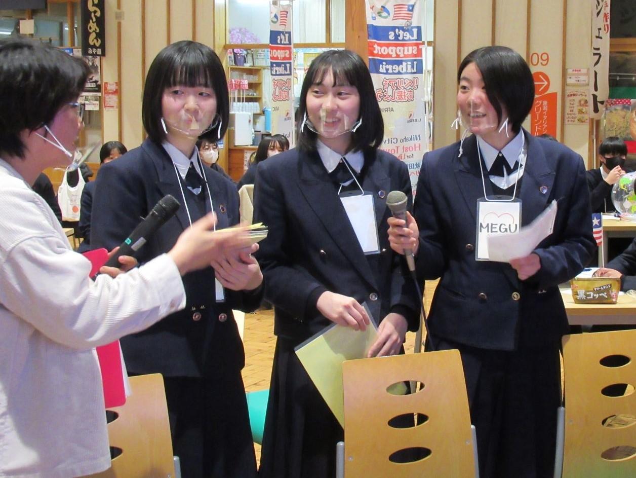 オンライン交流会にて、進行役からの話に手持ちマイクで答える由利高校生徒3人の写真
