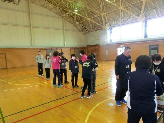金浦体育館にて、体育館中央に置かれた長机の前に並ぶ参加者たちの写真