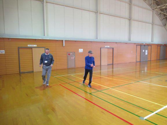 体育館内でインターバル速歩の実技を行う2人の参加者の写真