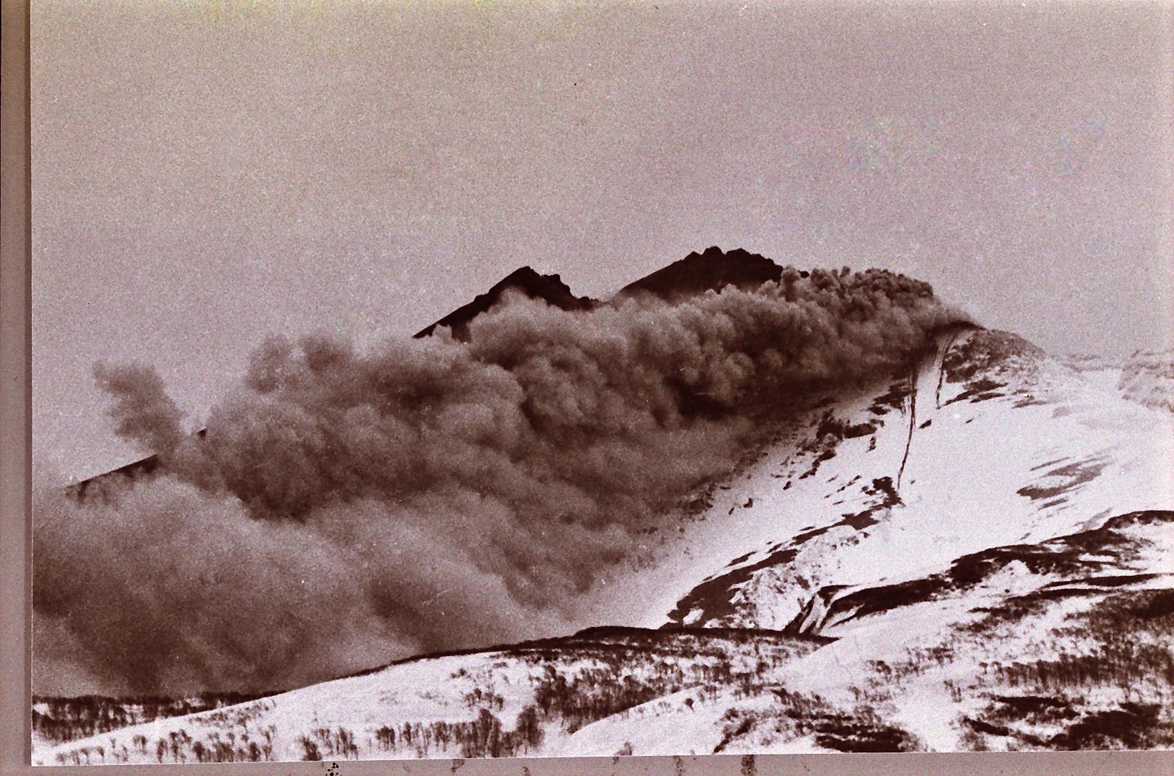 煙が立ち込める火山を遠方から撮影した2色刷りの写真