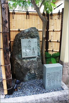 竹の塀に囲まれた句碑の写真